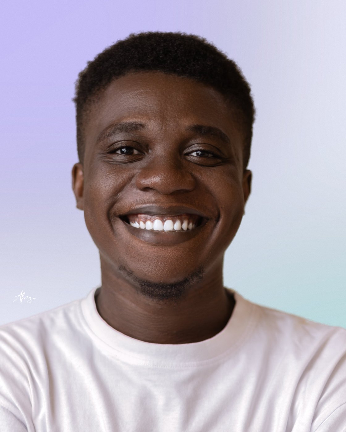 Moses Afolabi smiling, in a white t-shirt